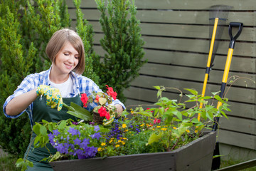 Young smiling woman florist working in the garden.