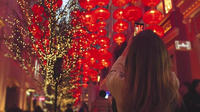 Young woman taking photo of red latern. Chinese new year red paper latern decoration in Hong Kong city.