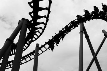 Black and White of People ride roller coaster, legs swinging back and forth as gravity. This image...