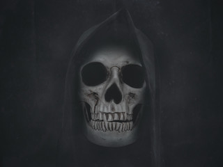 Human skull in hood. Halloween grunge background