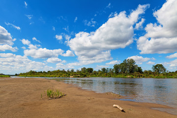 Blue cloudy summer sky over Bug river, Poland, Europe