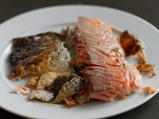 Lachsfilet mit eingeriebenem Fenchelkraut und der knusprigen Haut auf einem Teller angerichtet