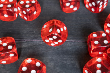 Red dice on dark wooden background, concept of risk, gambling and chance.