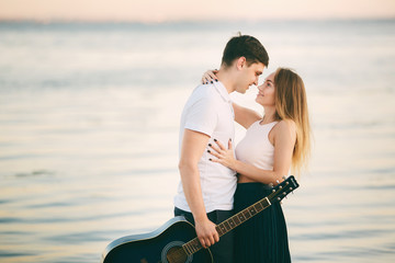 Young happy couple kiss on seashore