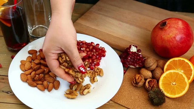 A woman with her own hands puts walnuts on a plate. Hd shot with dolly .The camera moves from right to left.