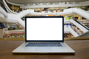 Front view of the laptop with blank white screen on wooden table in blurred office background