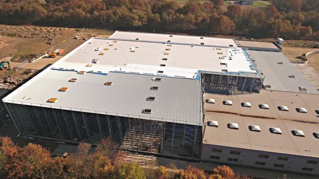 Flying around a new build warehouse building in bird's eye view 4K