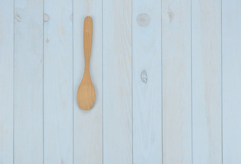 Artículos de cocina: cuchara de madera sobre fondo azul
