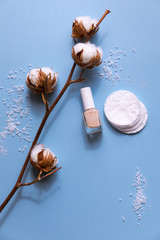 Cotton pads for removal makeup with cotton flowers on the blue background flat