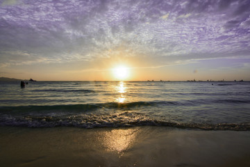 Sunset in tropical island of boracay with white beach and coconut palms in philippines