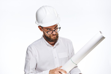 Engineer with a beard on a white isolated background holds a drawing