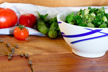 Tomato and cucumber salad with black pepper on wooden rustic table