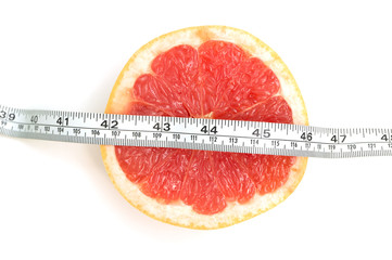 Fresh grapefruit and tape measure and for fitness on white background, concept of slimming, healthy lifestyles and nutrition