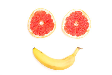 Smiling face made from grapefruit and banana on white background