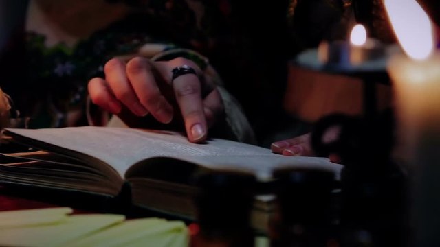Experienced witch reading spellbook, magic atmosphere and attributes, wizardy