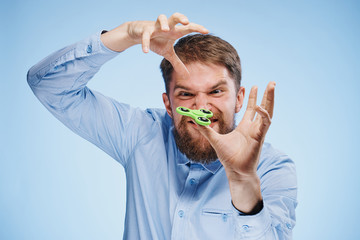 A young guy with a beard on a blue background holds a spinner