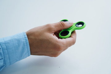 A man's hand holds a spinner on a white isolated background