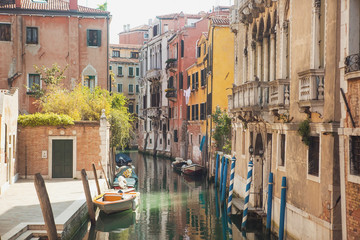 Fototapeta na wymiar Italy, Venice. Canal with boats and gondolas.