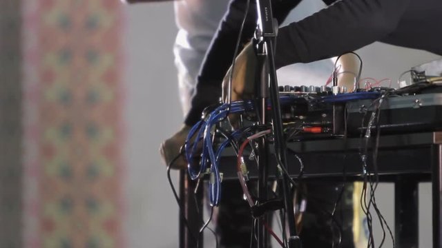 Hands of sound engineer connecting wires into dj's mixer, music equipment