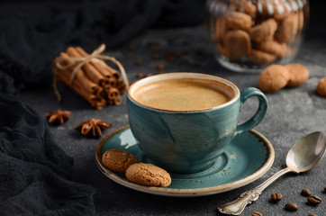 Cup of fresh coffee with Amaretti cookies on dark background, selective focus
