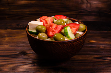 Greek salad in a bowl on wooden table