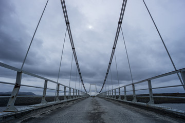 Iceland - Rope bridge over river with dark atmosphere