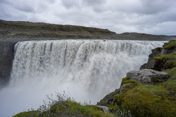 Iceland - Moss covered green stones at magical detifoss waterfall
