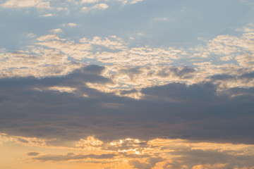 Bright  dark and yellow cloudy sky at sunset or sunrise