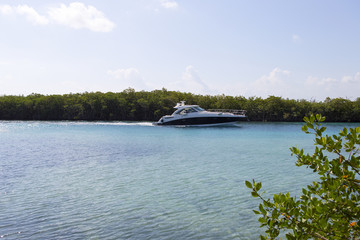 Luxury yacht speeding on a lagoon.