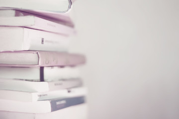 Book stack background represents reading concept, low contrast, blurred photography, selective focus. A relaxing and modern wallpaper for positive thinking and happiness.