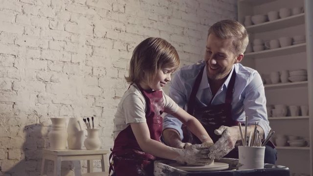 Dad with a child in a potter's workshop