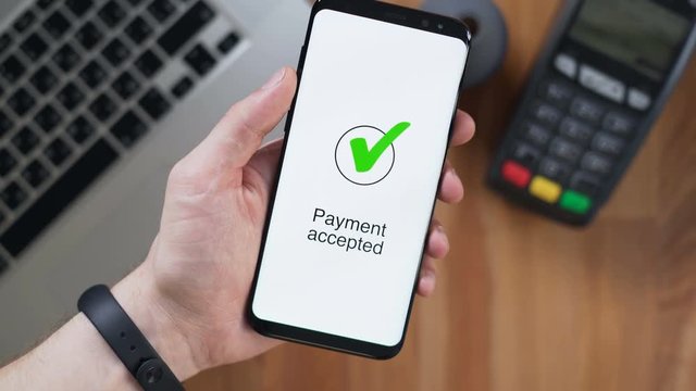 One male person pay in a trade with nfc system without contact in office. Close up shot mans hold device with telephone app for banks payments use wireless. Process of transfering fund from cards