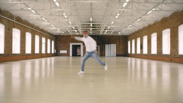 Male breakdancer dancing in sport gym