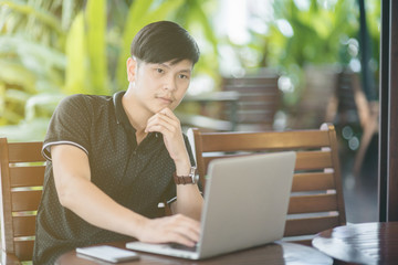Businessman working laptop for new architectural project, sitting at table in cafe and uses laptop.Nearby is smartphone. Generic design notebook on the table. Freelancer working outside office