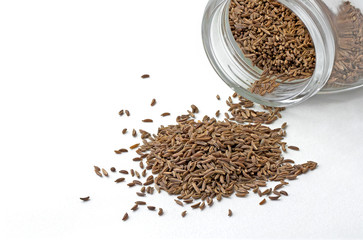Isolated closeup cumin seeds in the jar