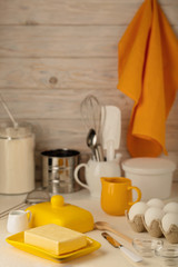 Kitchen utensils, tools and products for homemade cakes on a light wooden background.