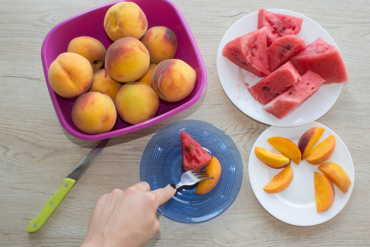Slices tasty watermelon and peaches on a white plate. Triangle shaped watermelon slices and slices peaches