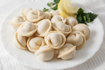Frozen dumplings on the white plate with green