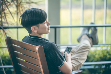 Attractive businessman using smartphone while sitting on sofa at his home.Concept of young people working mobile devices.Closeup with a selected focus.Blurred background. business.