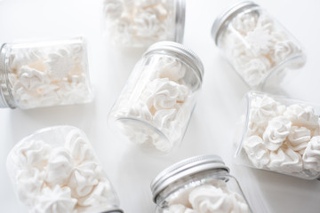 Fototapeta na wymiar meringue cookies in jars on a white background