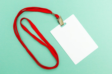 Blank badge mockup isolated on green. Plain empty name tag with red string.