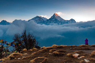 Unidentified person taking photo of Annapurna mountain range at Poon Hill view point in Nepal. Poon Hill is a popular destination for trekkers in the Annapurna region of Nepal.