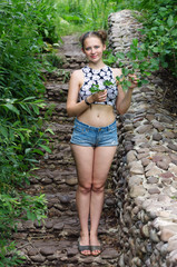 Blonde girl in shorts on stone steps / Photo taken in Russia, in the Orenburg region, near the village of Tugustemir on the descent to the Silver Spring
