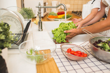 Father with son washes vegetables before eating