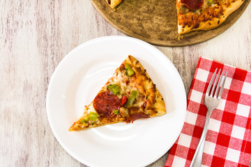 Slice of Pepperoni and Vegetable on Plate With Fork and Napkin