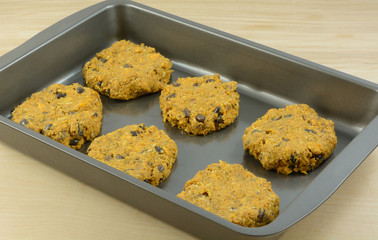 Raw sweet potato, sausage and black bean patties in baking pan