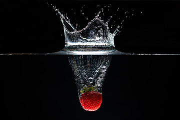 A strawberry splashing into water