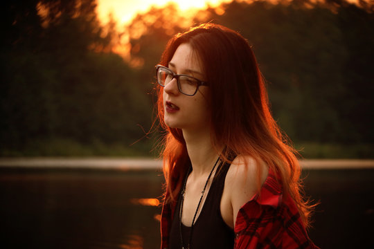 Young pretty woman in sunlight is smiling and touching herself