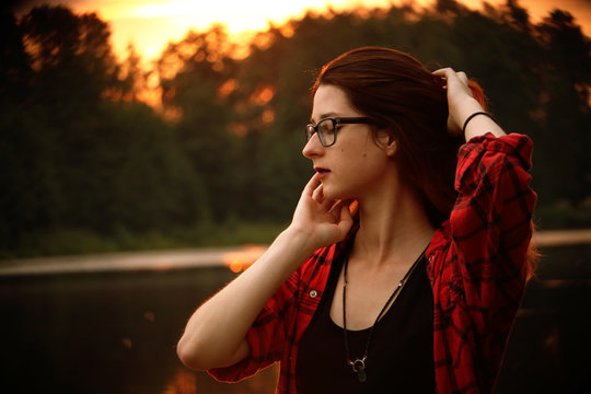 Young pretty woman in sunlight is smiling and touching herself