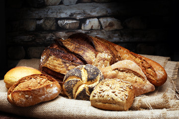 Different kinds of bread and bread rolls on wooden table